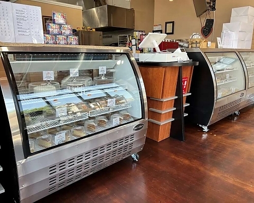 Indoor view of bakery with a large counter top featuring the signature custom cakes.