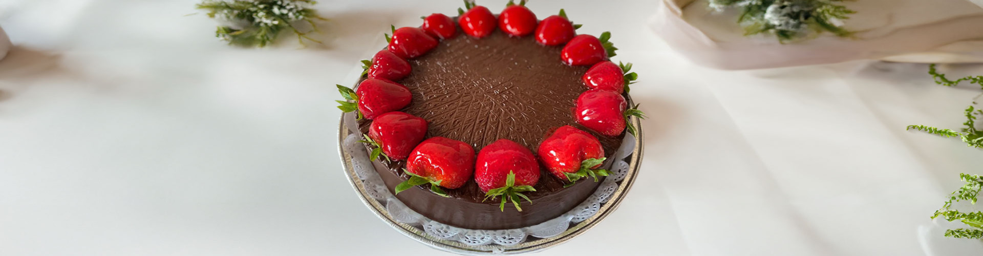 A cake with a flower and strawberries on top of it showcasing oreo tres leches.