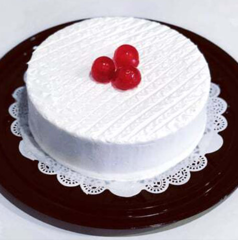 A white cake with a blue frosting on it showcasing tres leches cake.