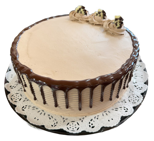 A cake with a carrot and a piece of cake showcasing oreo tres leches.