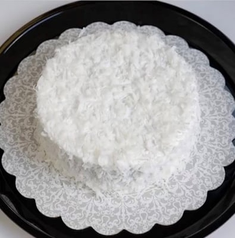 A white plate topped with a cake showcasing cake delivery.