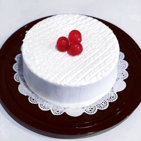 A white cake with a blue frosting on it showcasing rumchata tres leches.
