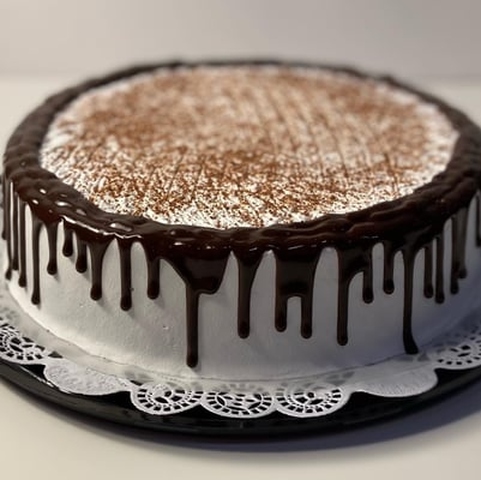A cake with a frosting on top of it showcasing tres leches cake.