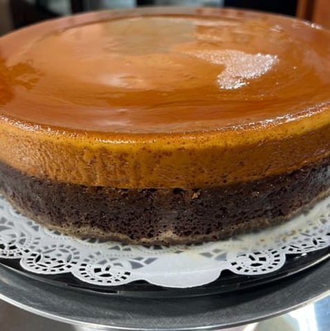A cake with a frosting on it showcasing oreo tres leches.