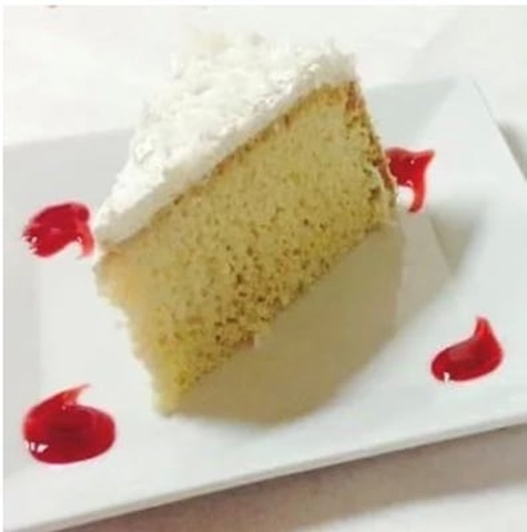 A piece of cake with a slice cut out of it showcasing rumchata tres leches.
