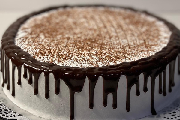 A chocolate cake with frosting on top showcasing cake delivery.