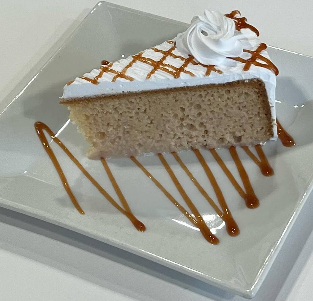 A piece of cake with frosting on a plate showcasing oreo tres leches.