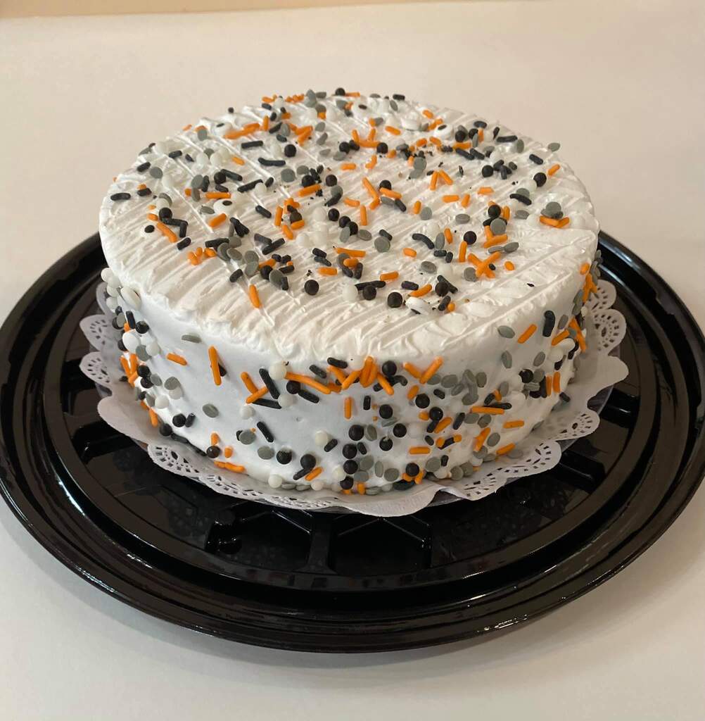 A cake with a blue and white frosting on it showcasing mango tres leches.
