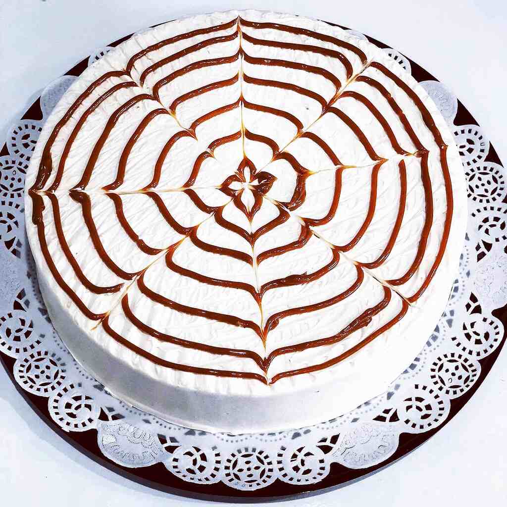 A cake with a white frosting on it showcasing strawberry tres leches.