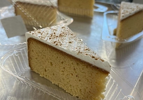 A piece of cake with a slice cut out of it showcasing oreo tres leches.