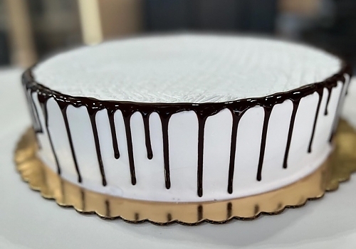 A piece of cake on a plate with a cup of coffee showcasing cake delivery.