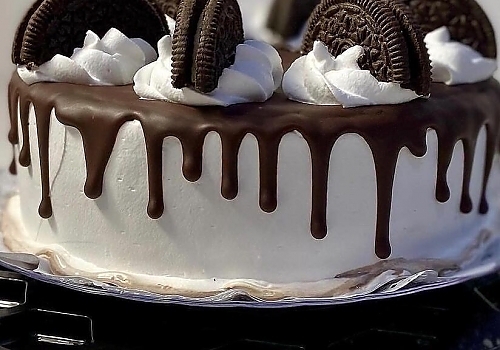 A piece of cake with strawberries on a plate showcasing oreo tres leches.