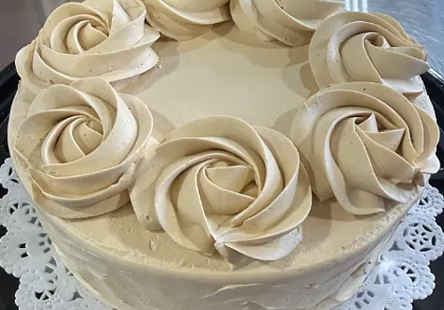 A cake with a white frosting on it showcasing strawberry tres leches.